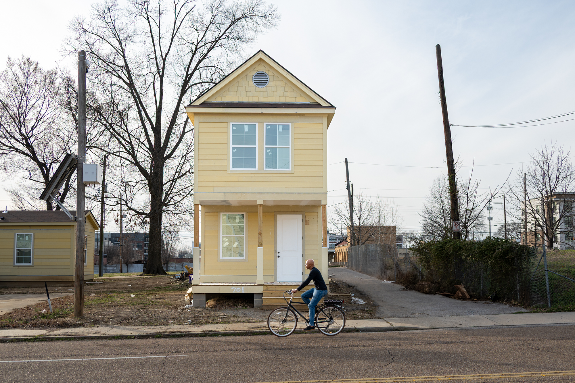 Andre Jones bikes in front of a new single-family home he’s helping build.